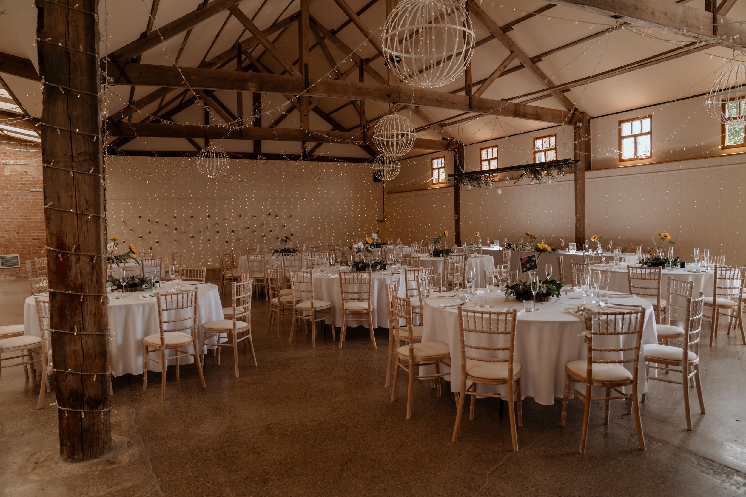 The Main Barn set with round tables and gold chairs