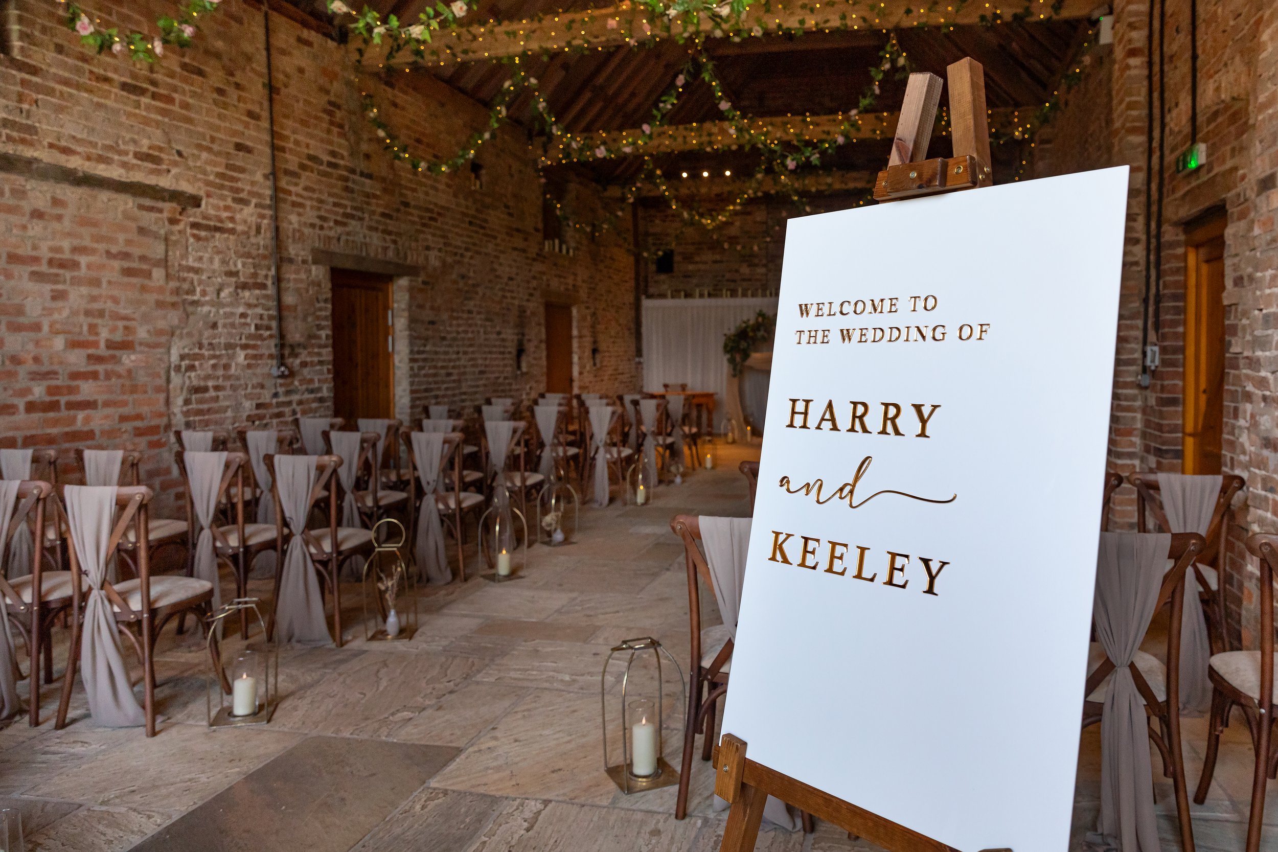 Rows of draped chairs and lanterns in the Ceremony Barn