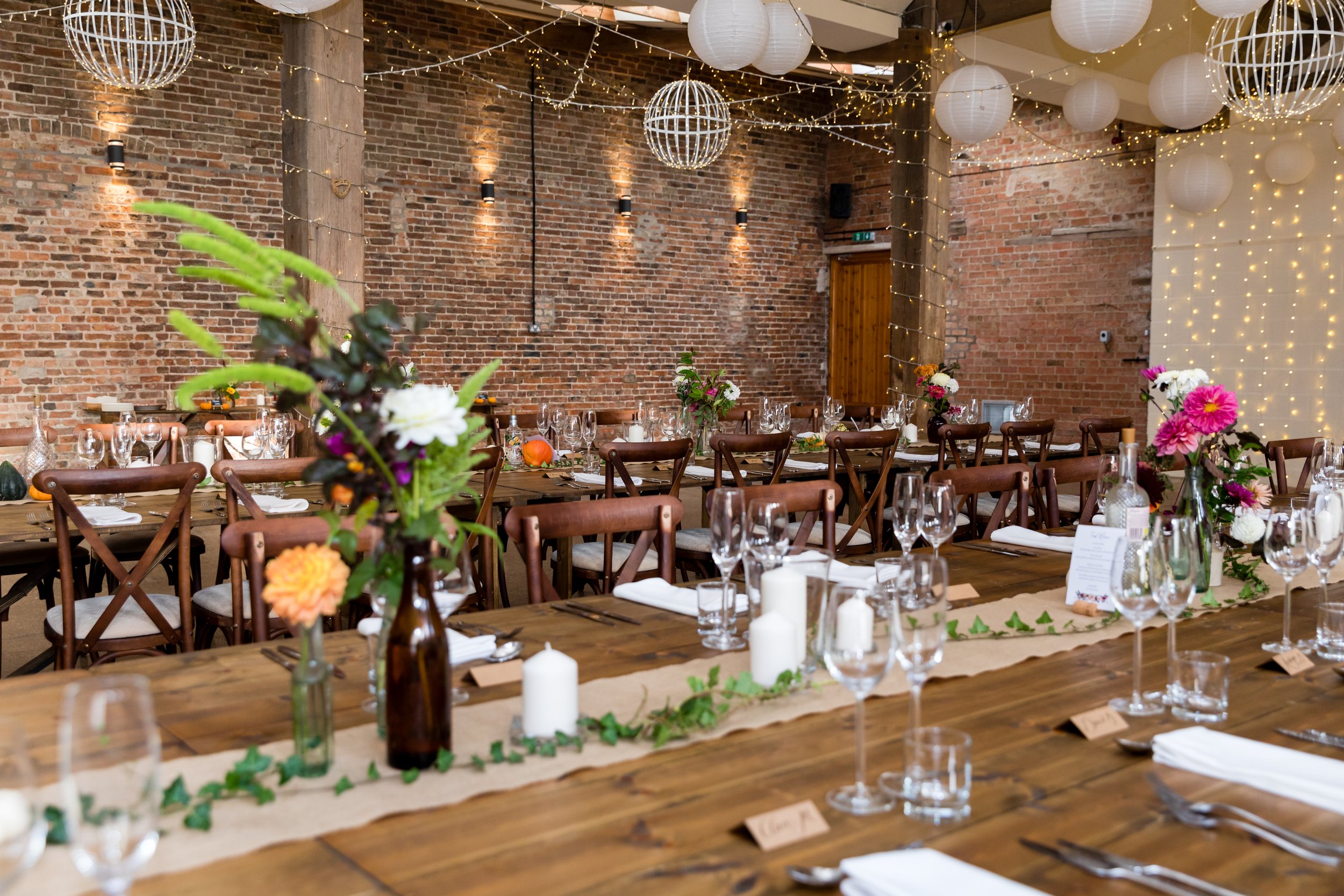 Long banquet tables dressed in the Main Barn