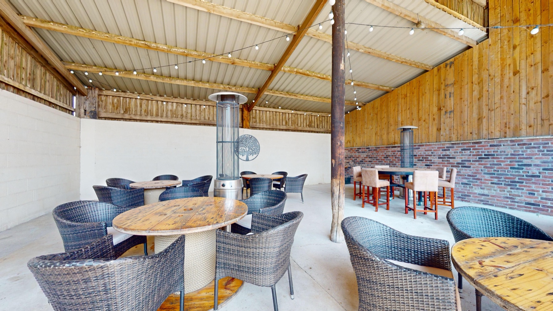 Rattan seating and patio heaters under the Outside Barn